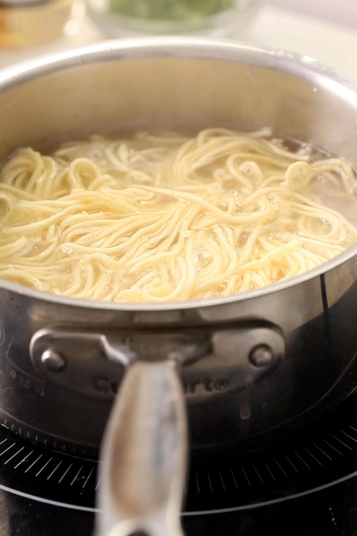Boiling noodles in a steel pot.