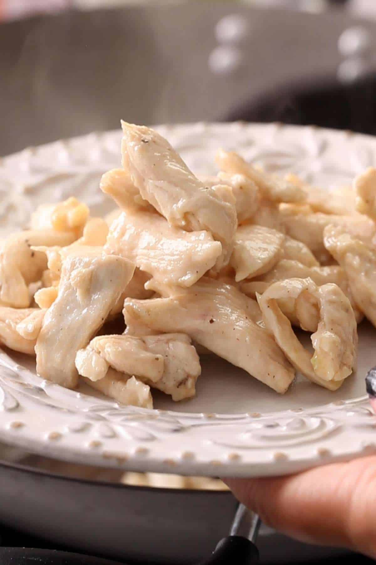 Take out cooked chicken in a plate. 