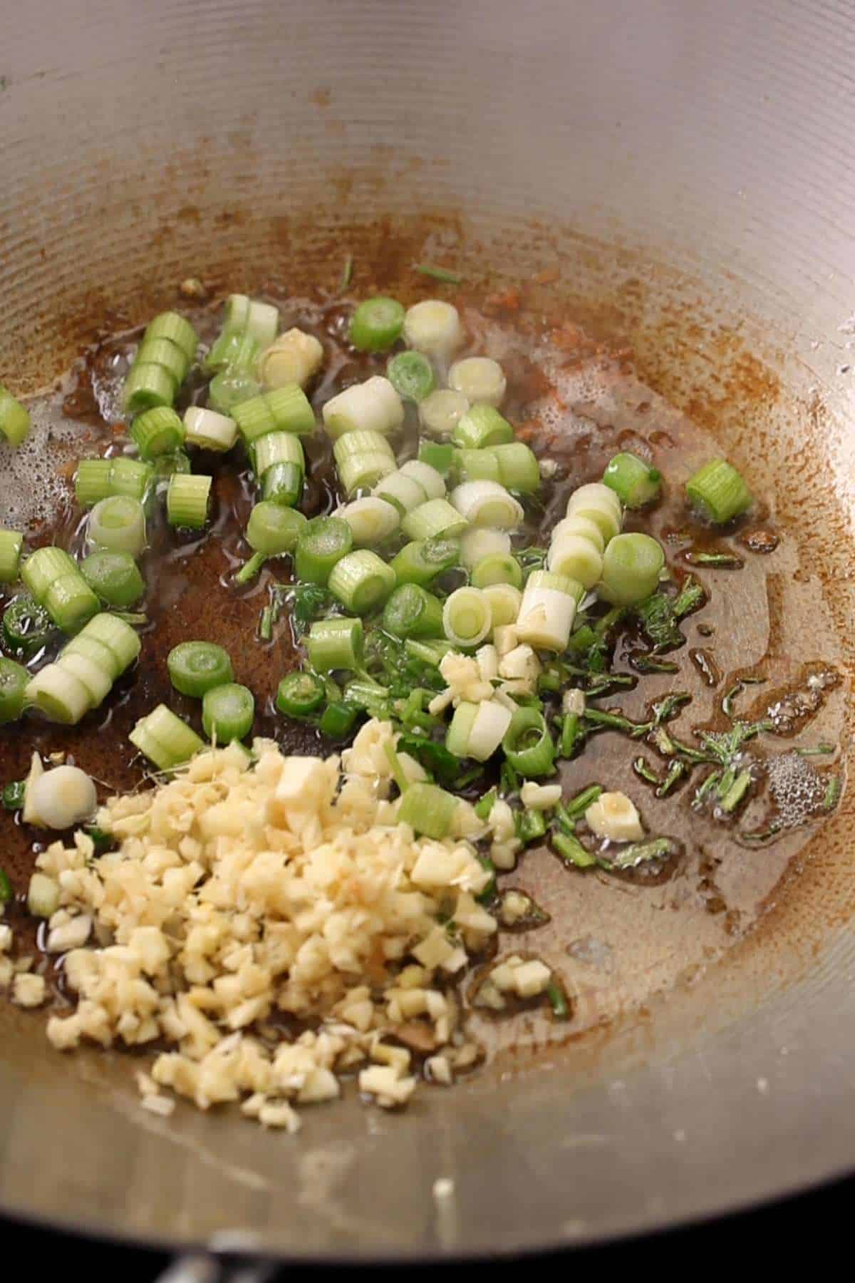 Fry alliums in a heated wok. 