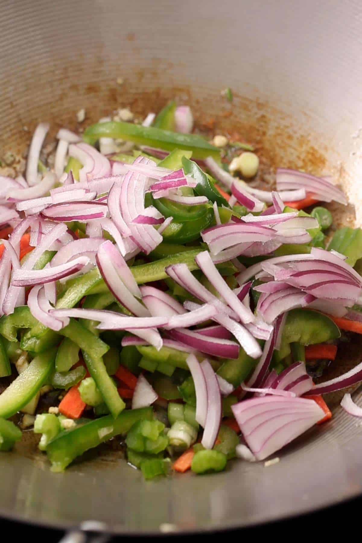 Add all colorful vegetables to the wok.