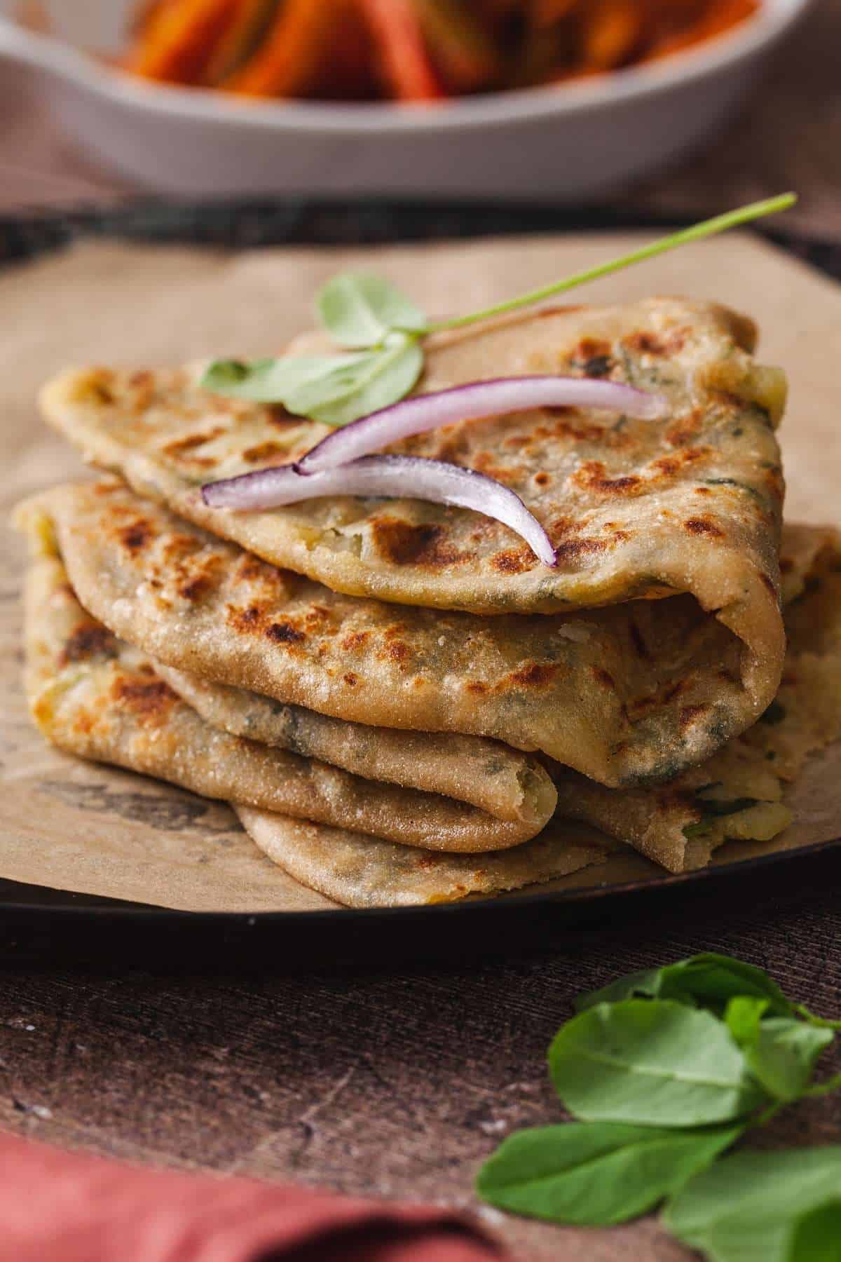 Side view of aloo methi paratha folded and stacked on each other. 