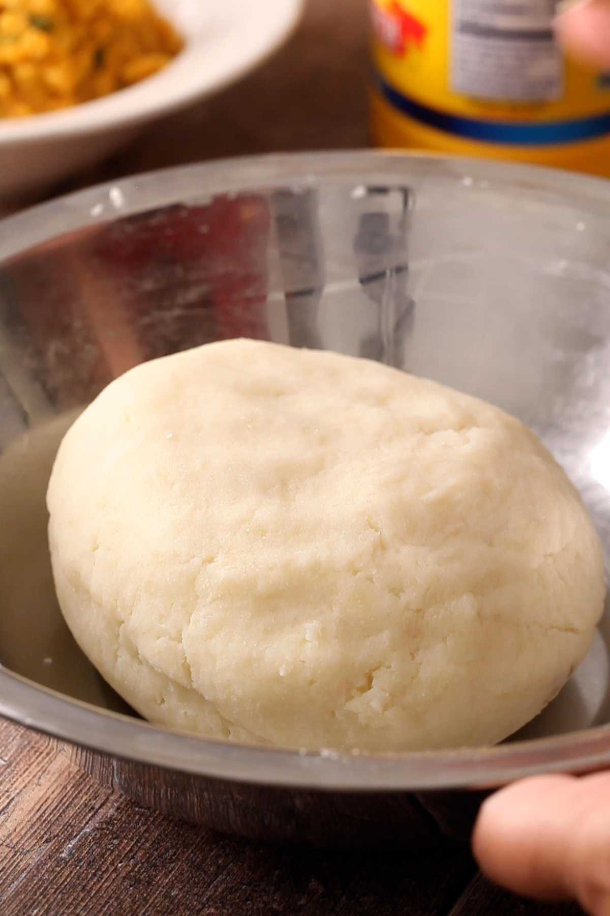 Potato dough in a stainless steel bowl.
