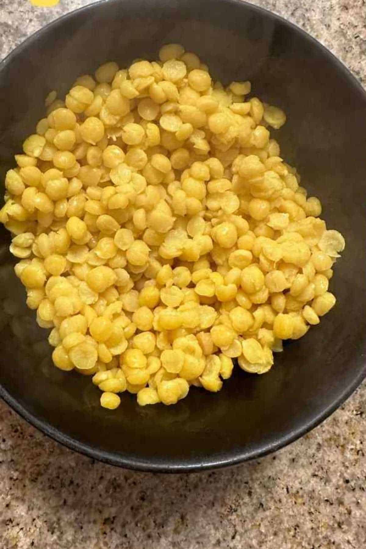 Boiled chana lentils in a black bowl.