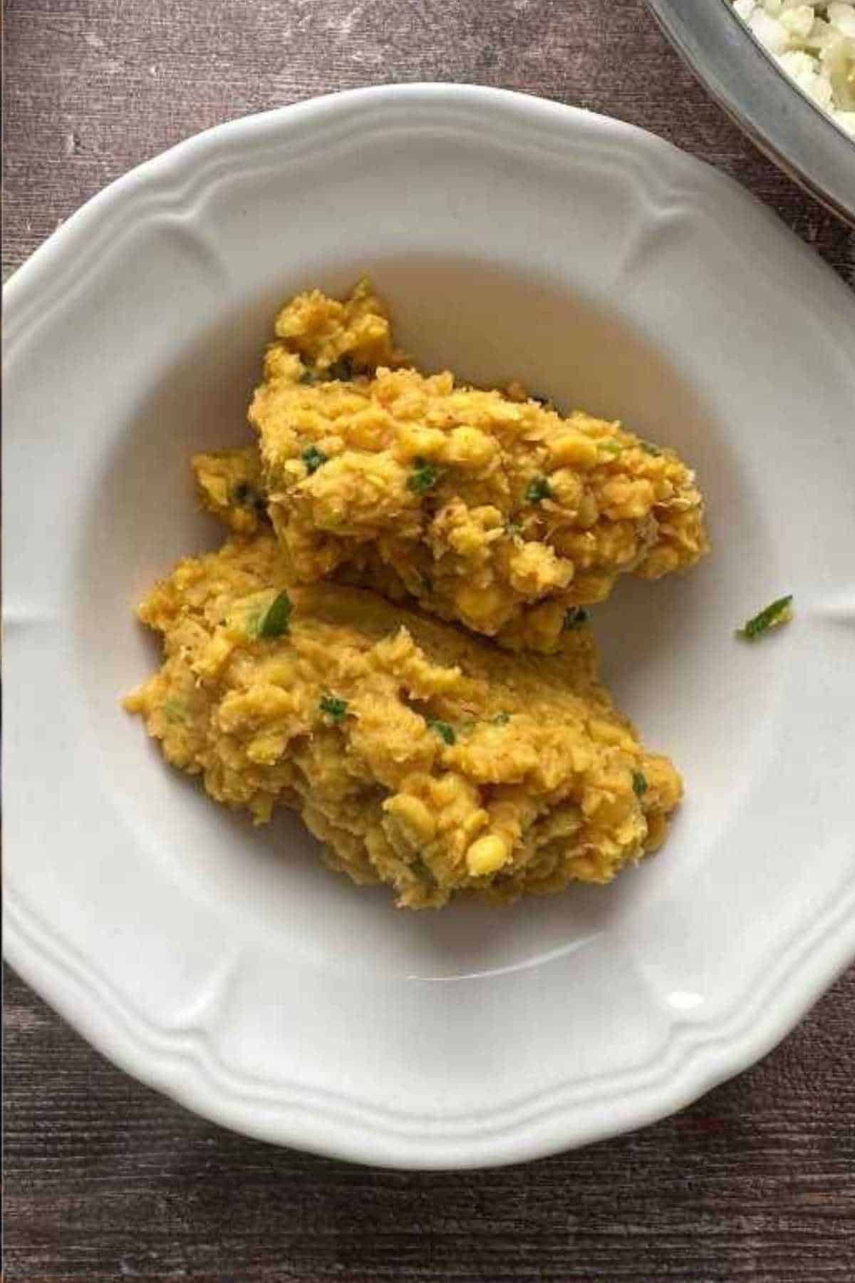 Placing the chana dal stuffing in a white bowl to cooldown.