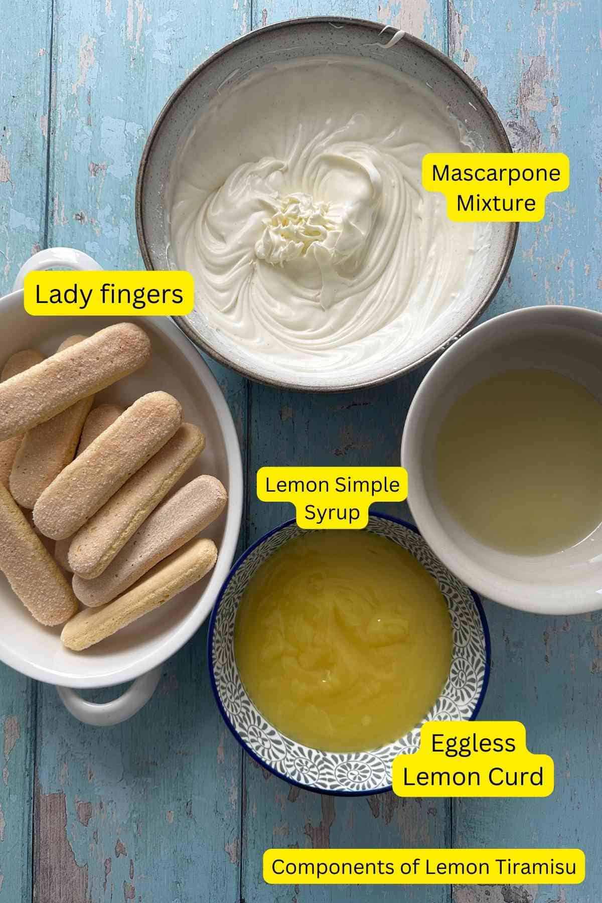 Different components of lemon tiramisu placed on a blue background before assembly.
