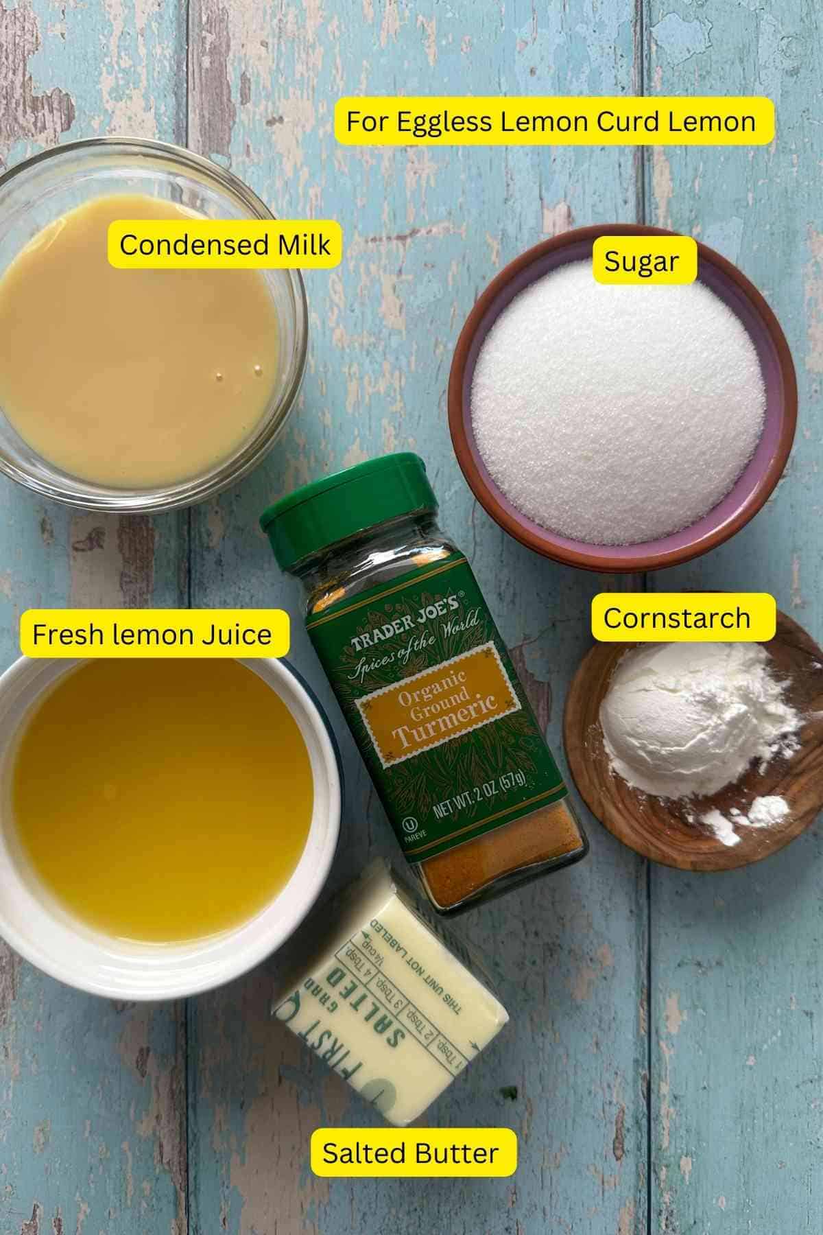 Ingredients needed to make eggless lemon curd on a blue background.