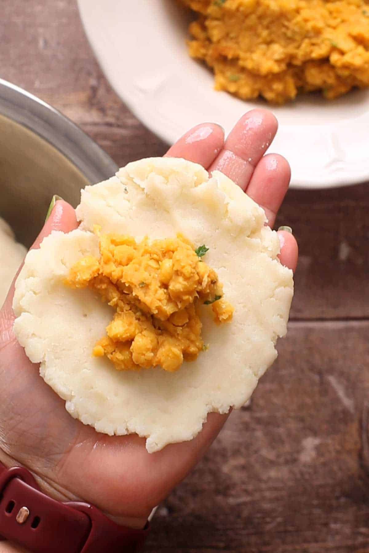 Stuffing aloo tikki with dal mixture.
