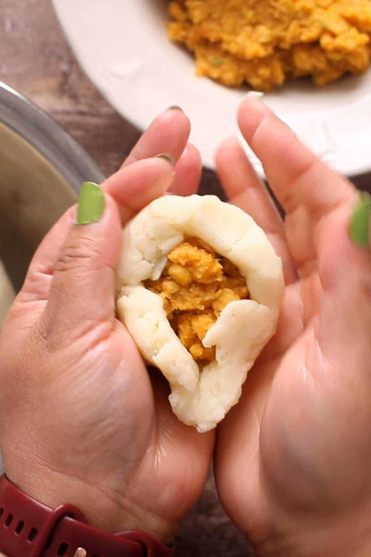 Shaping the aloo tikki stuffed with lentils.