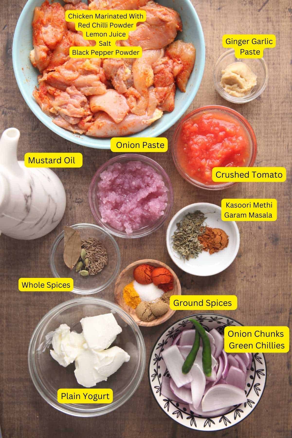 Ingredients needed for making chicken do piaza placed on a wooden board.