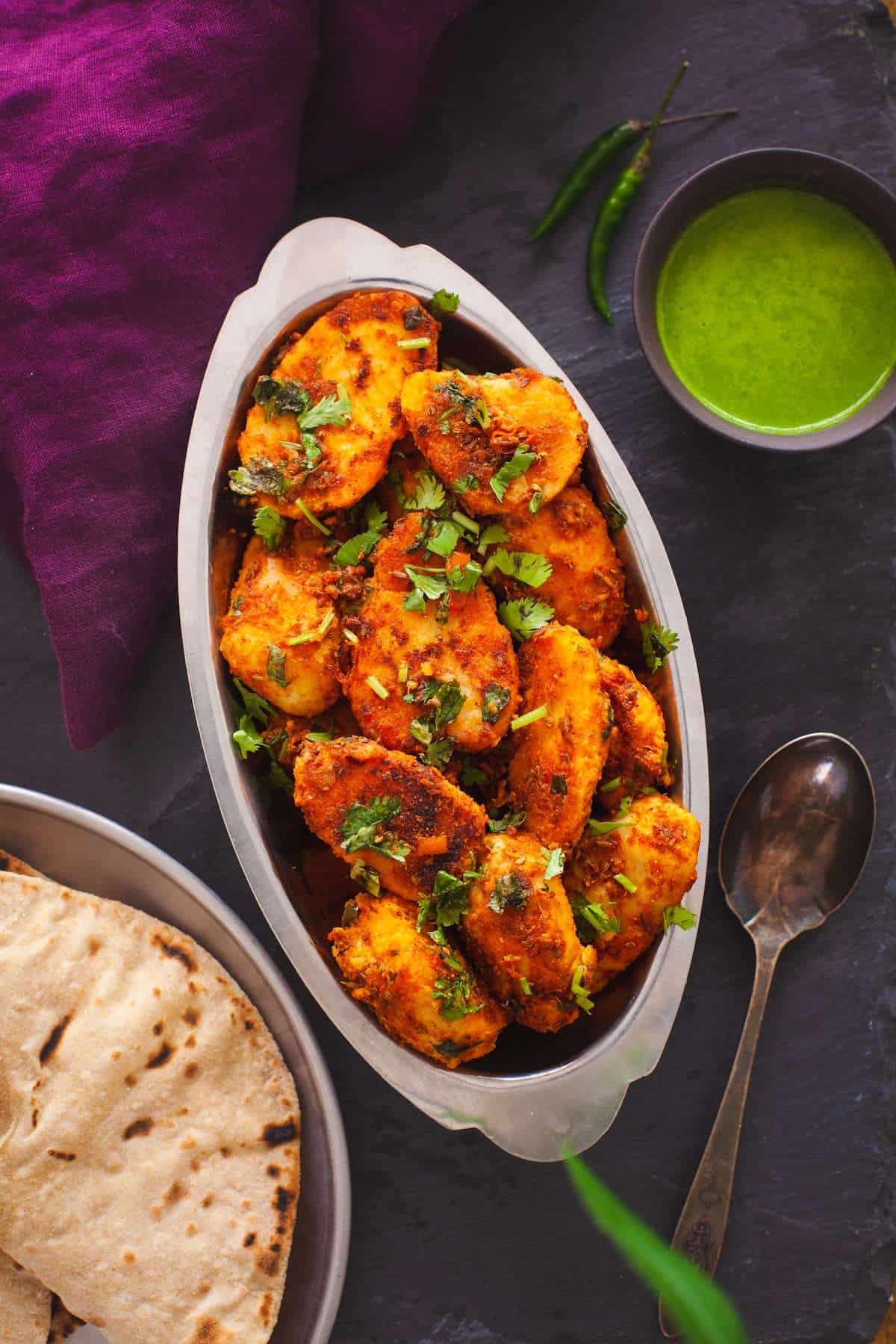 Arbi Fry served in an oval stainless steel dish and placed on a black background. 