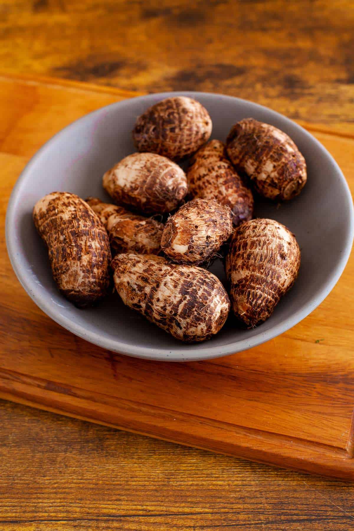 Raw Taro Root placed in a grey bowl.