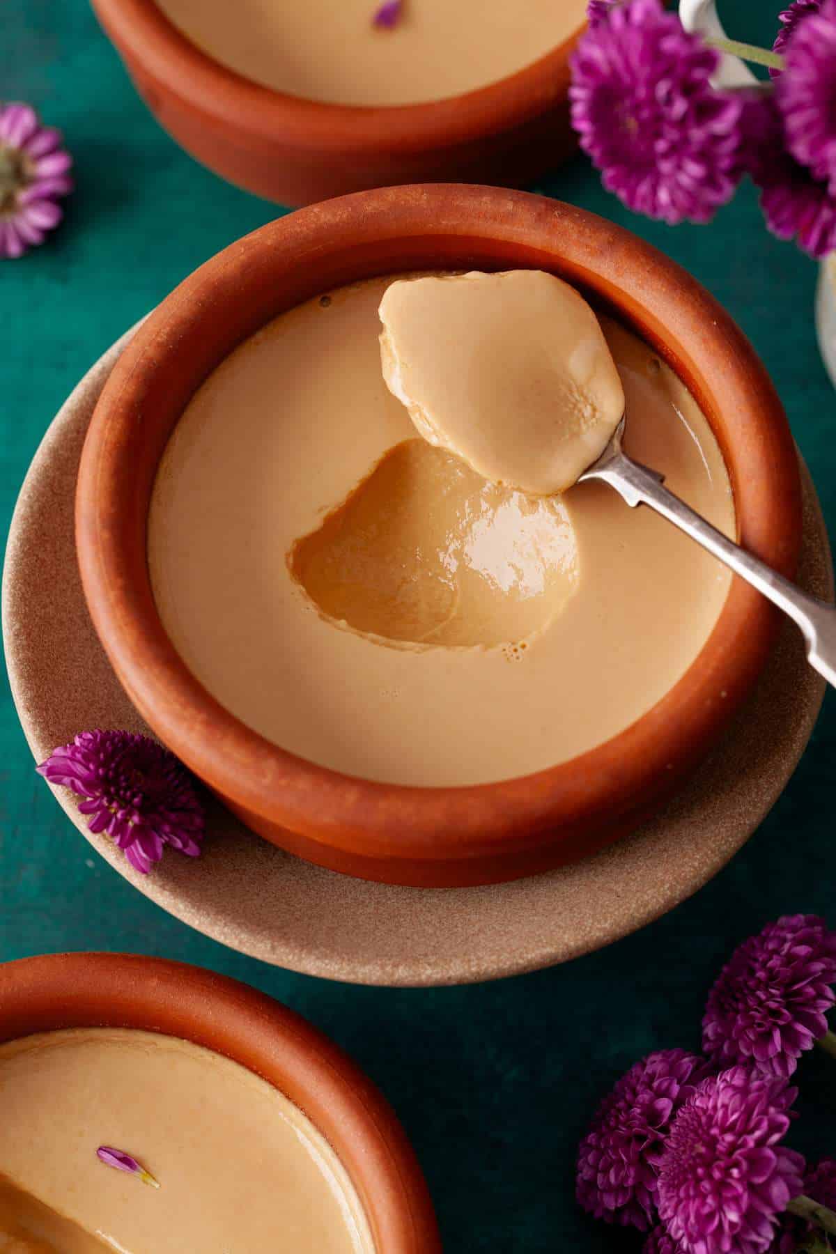 A small pot of mishti doi scooped up from the center.