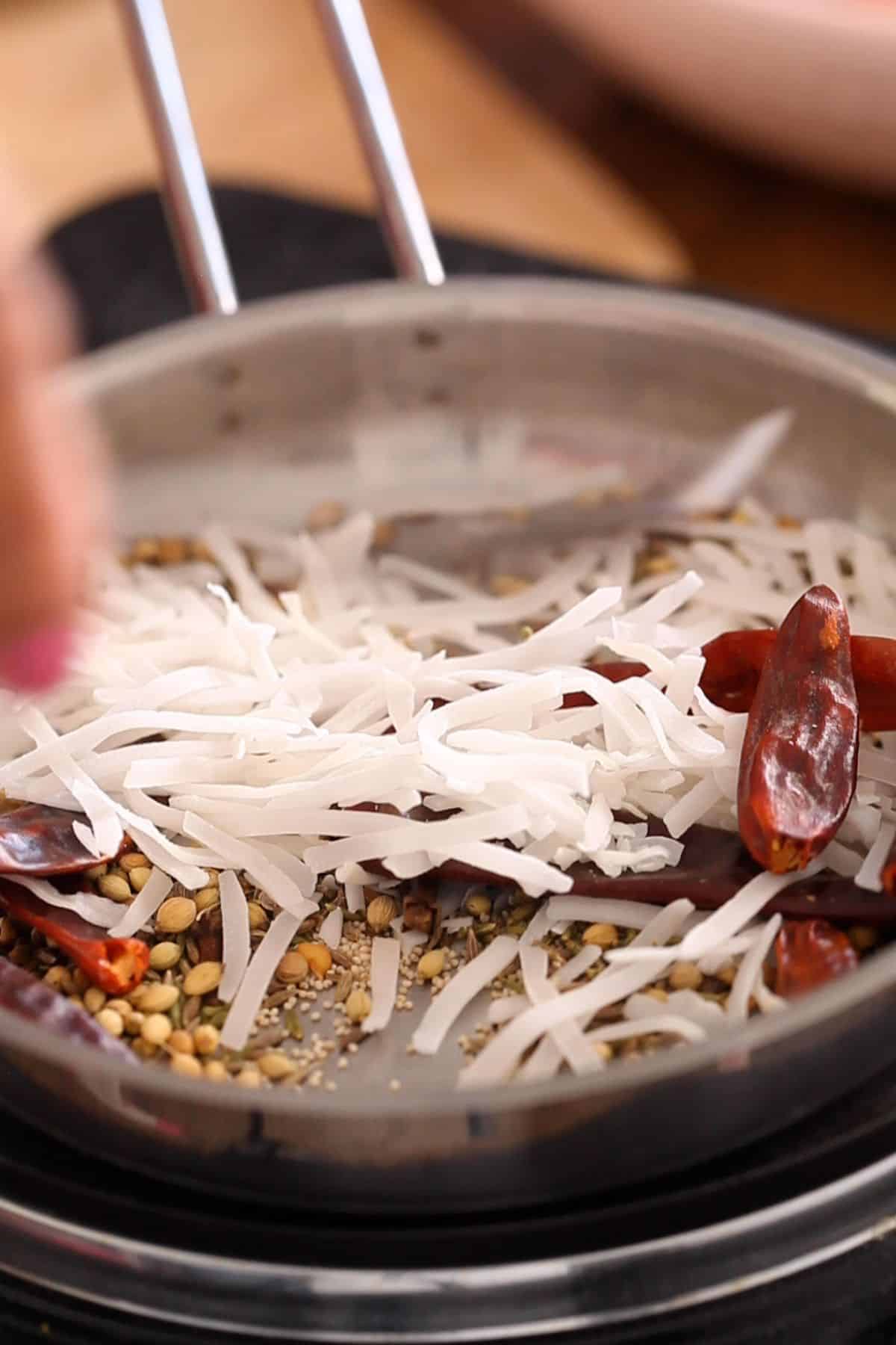 Dried coconut is toasted with the whole spices.