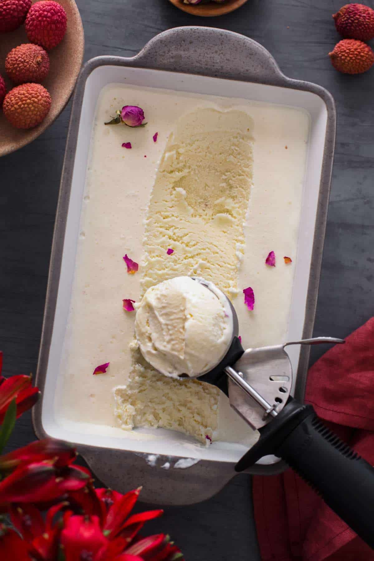 Homemade no churn lychee ice cream in a grey container. 