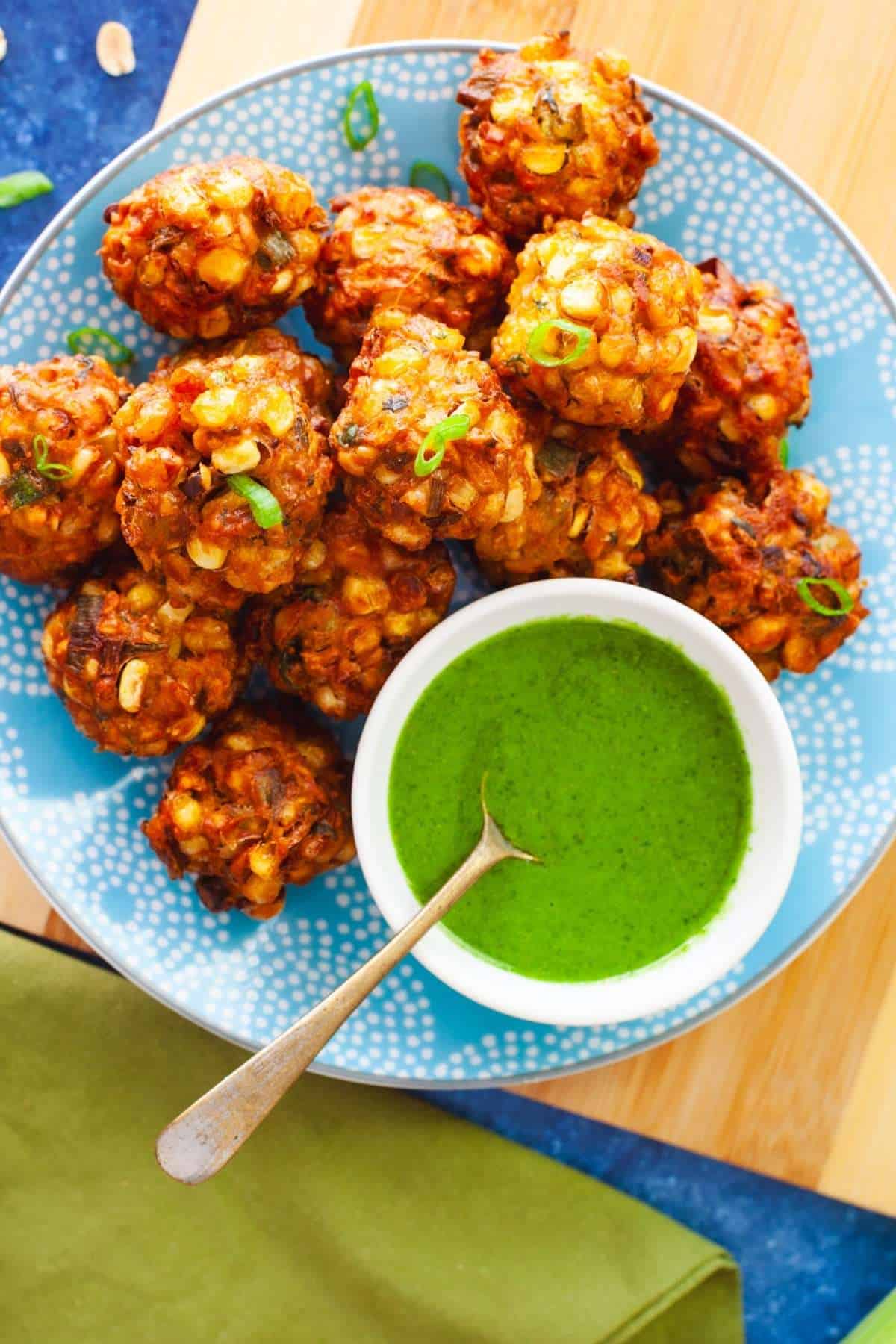 Corn Pakoda served with green chutney in a blue plate.