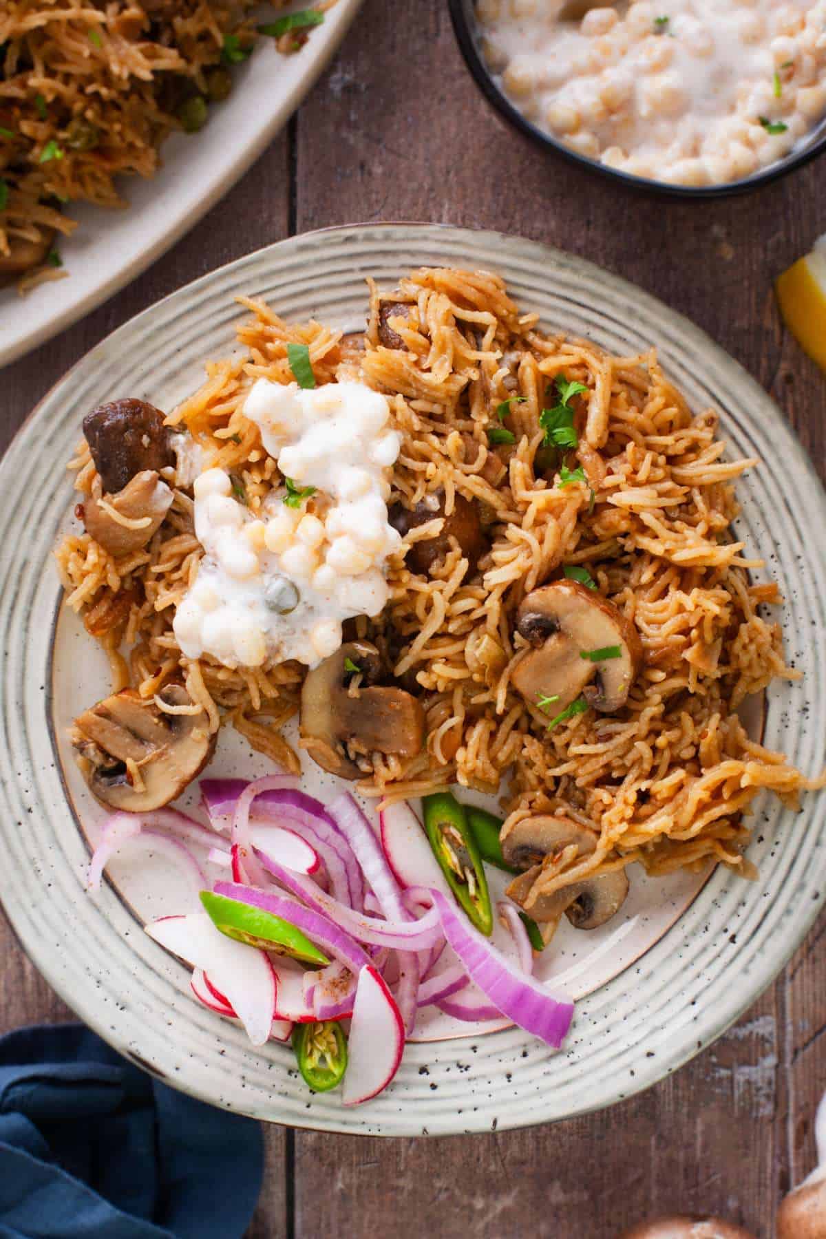 Mushroom pilaf served with yogurt raita and onions.