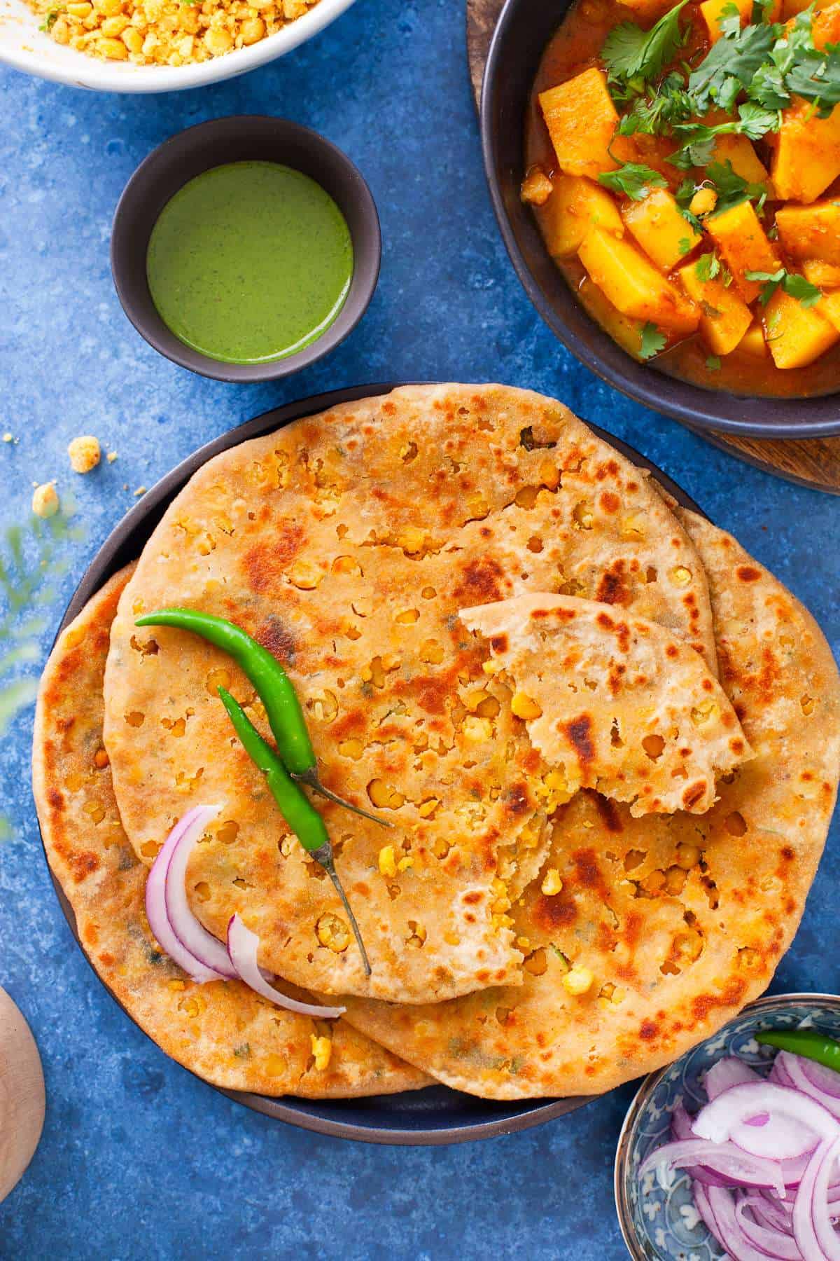 Chana lentil stuffed paratha on a black plate.