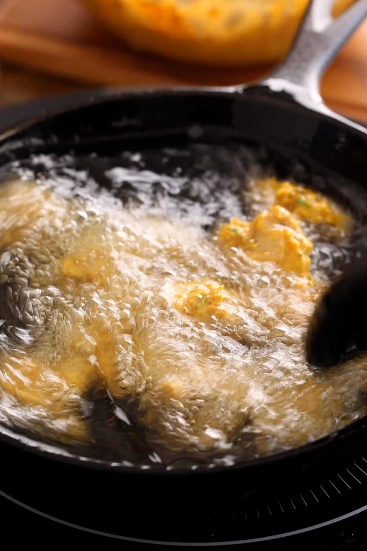 Deep frying chicken pakora.