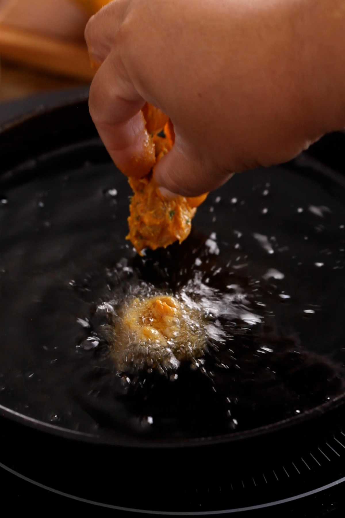 Checking oil temperture by adding one chicken piece to the oil. 