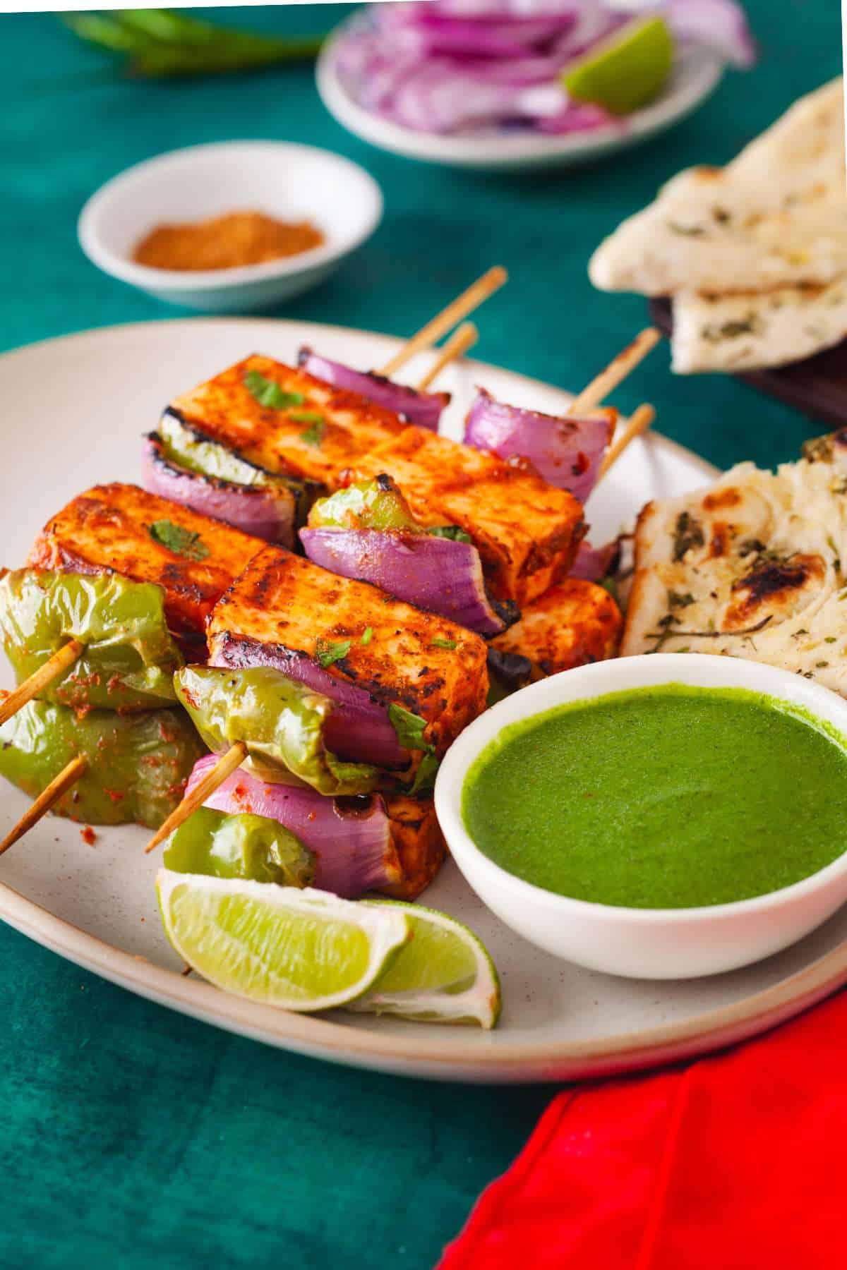 Side view of paneer tikka in a serving plate.