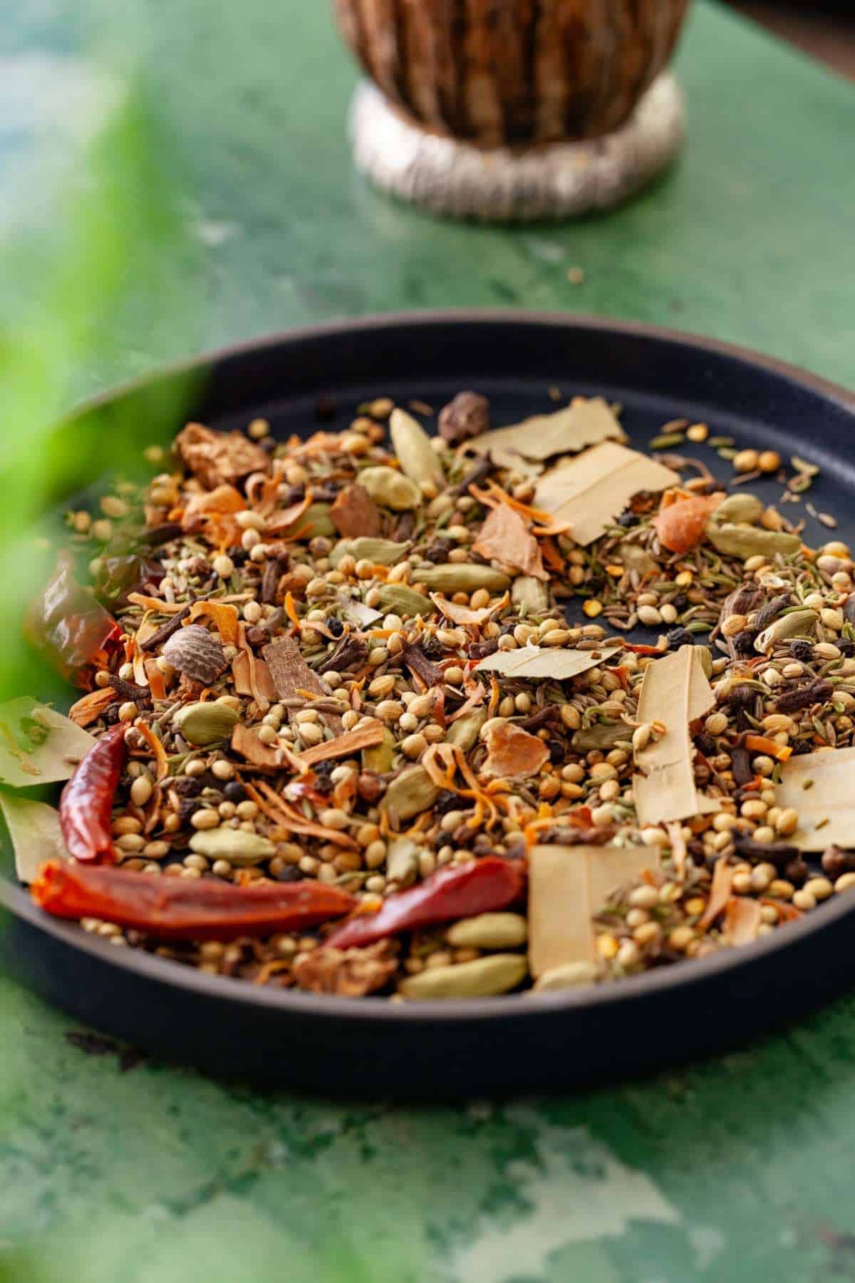 Cooling down roasted spices in a black plate.