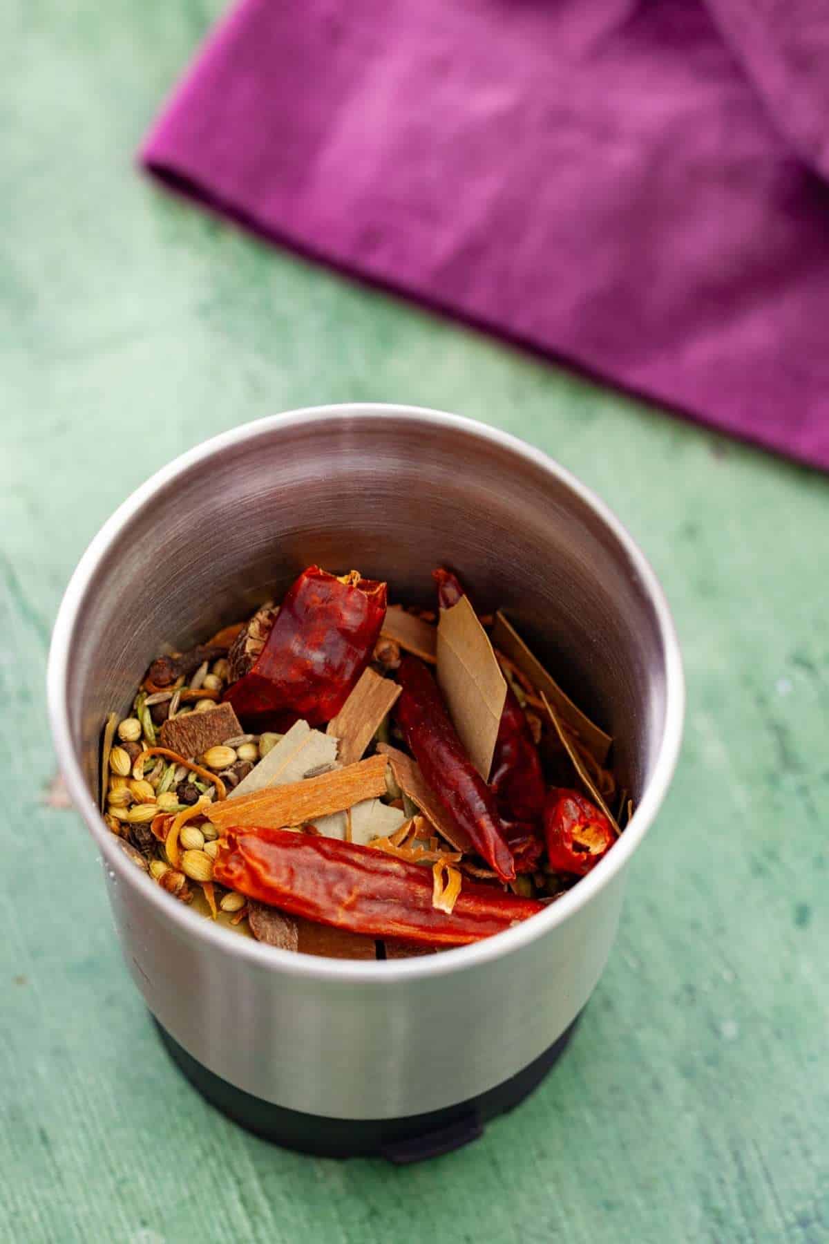 Whole spices in a grinder jar.