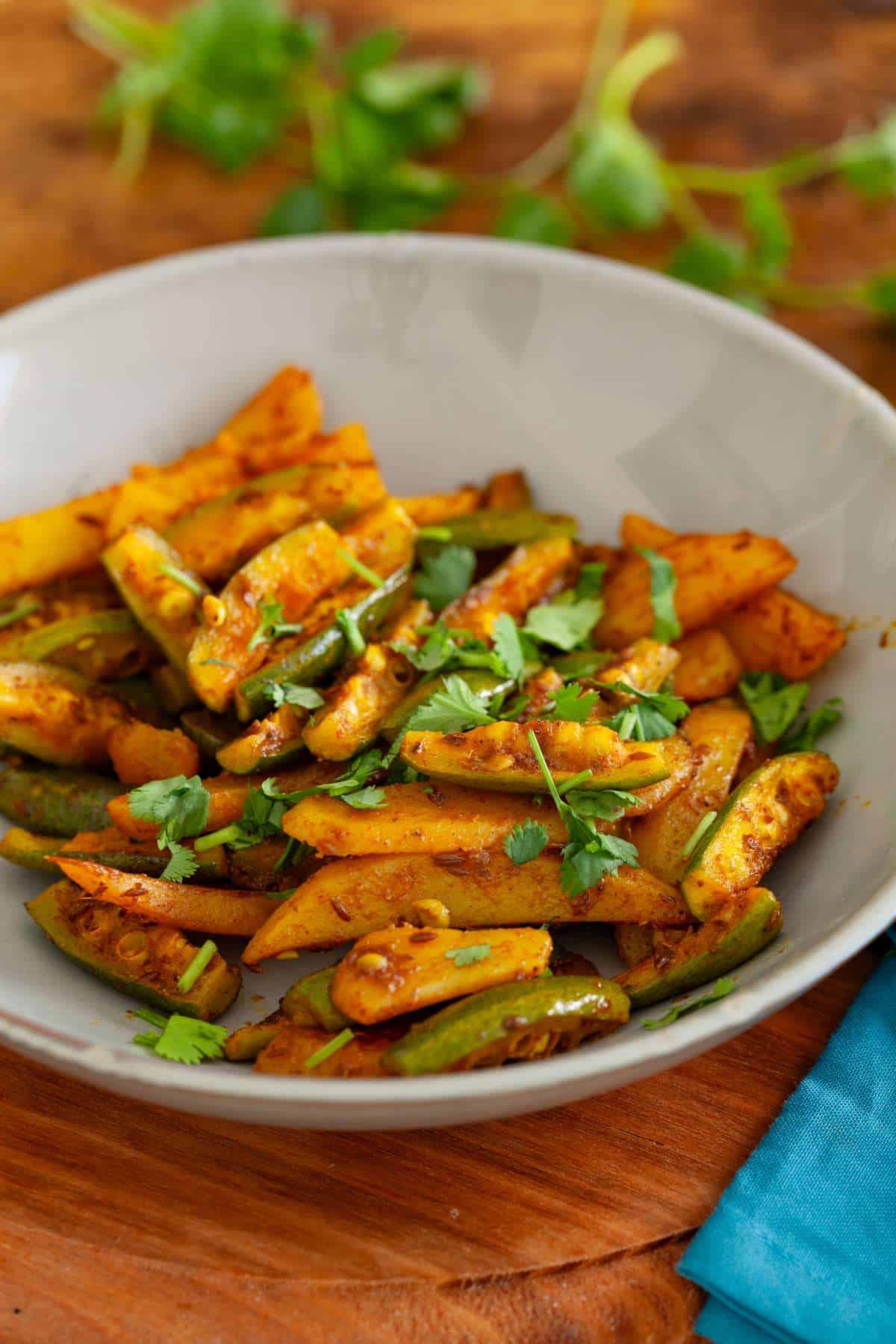 Parwal Sabji in a grey plate on a wood board.