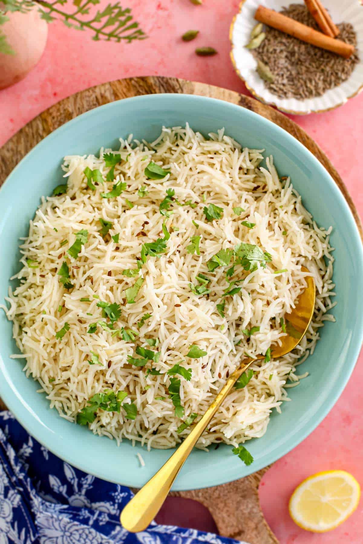 Jeera rice in a blue bowl garnished with cilantro.