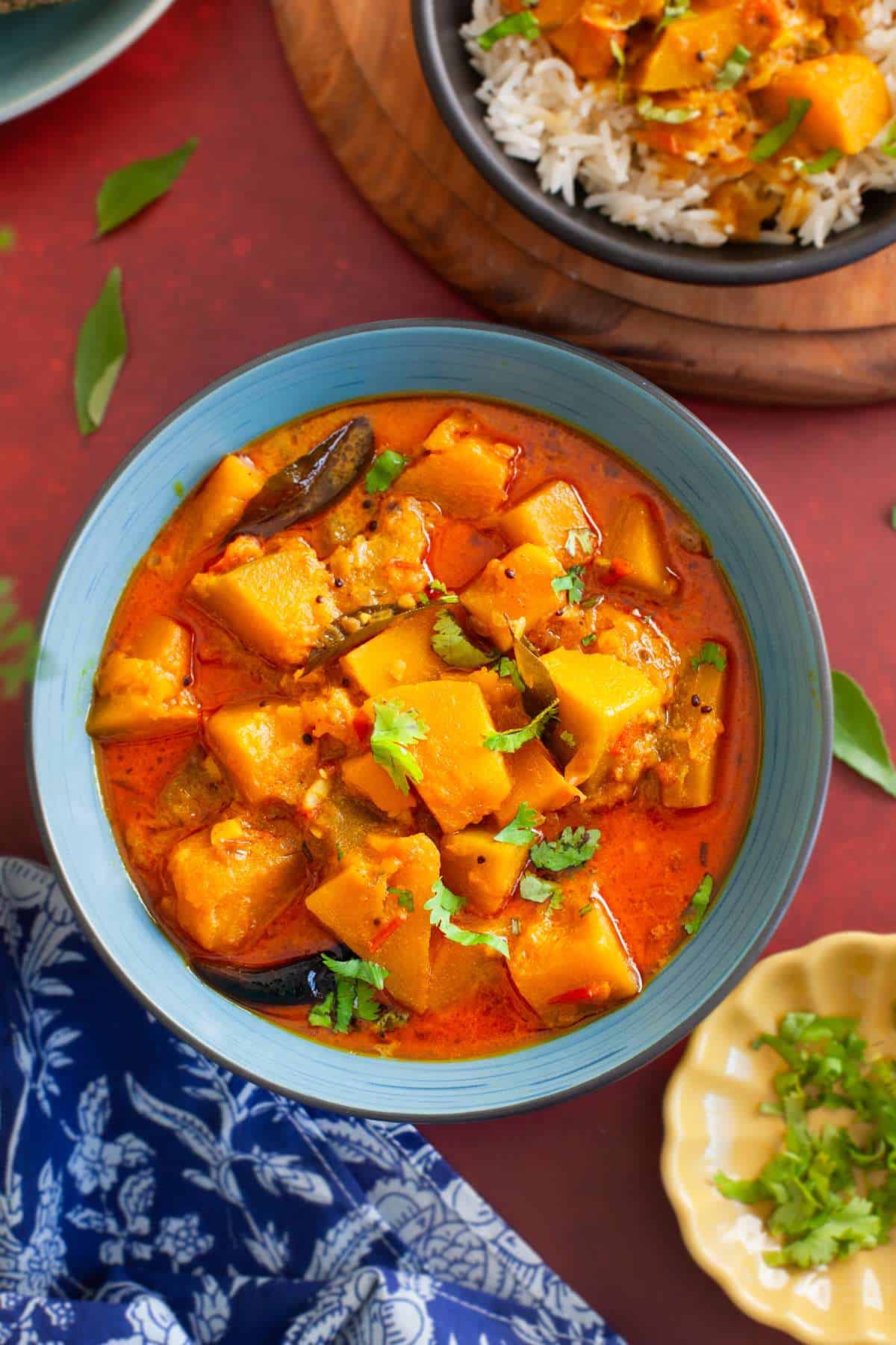 Indian pumpkin curry served in a blue bowl.