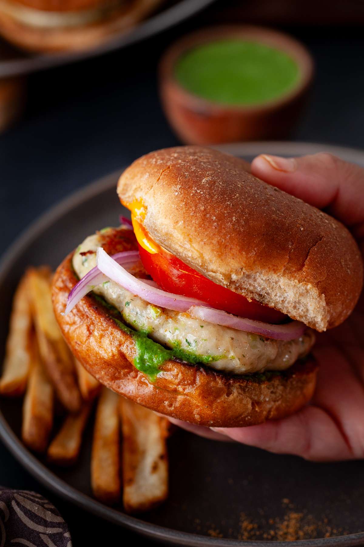Holding indian chicken burgers in hand.