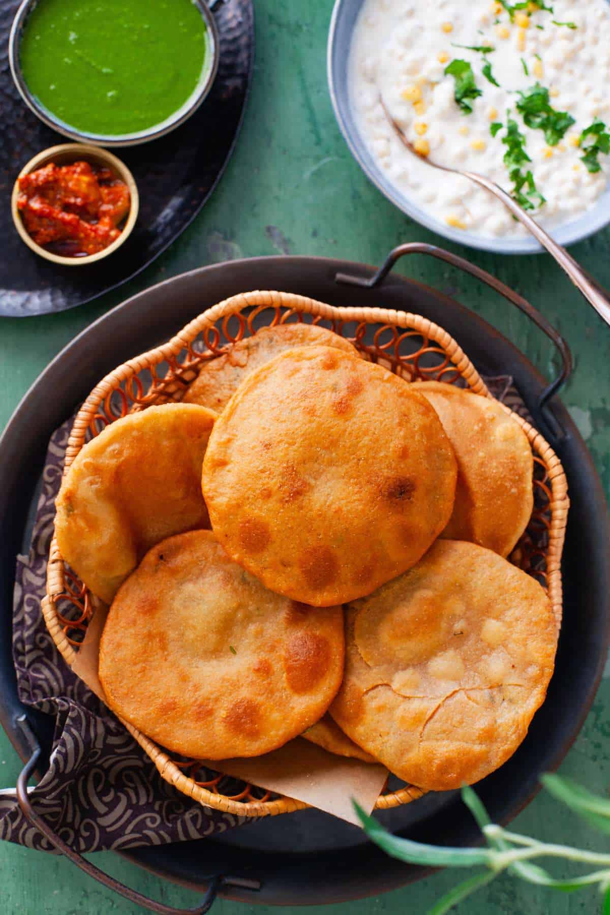 Aloo kachoris served with boondi raita and green chutney.