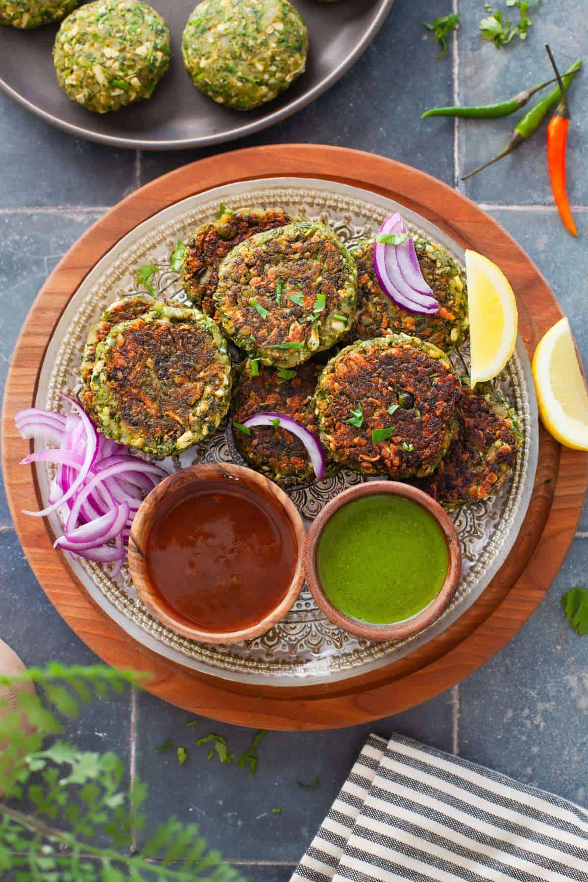 Hara Bhara Kabab served on a plate with sliced onion & chutneys.