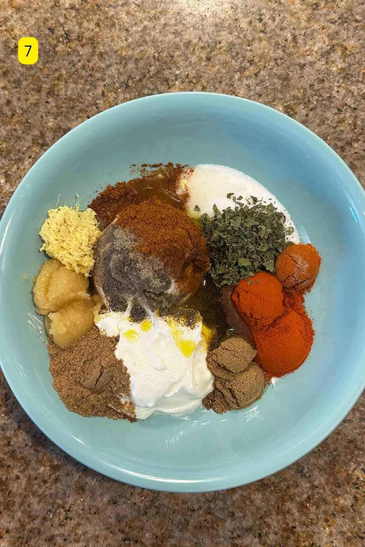 All the tandoori chicken marinade ingredients placed in a blue bowl.