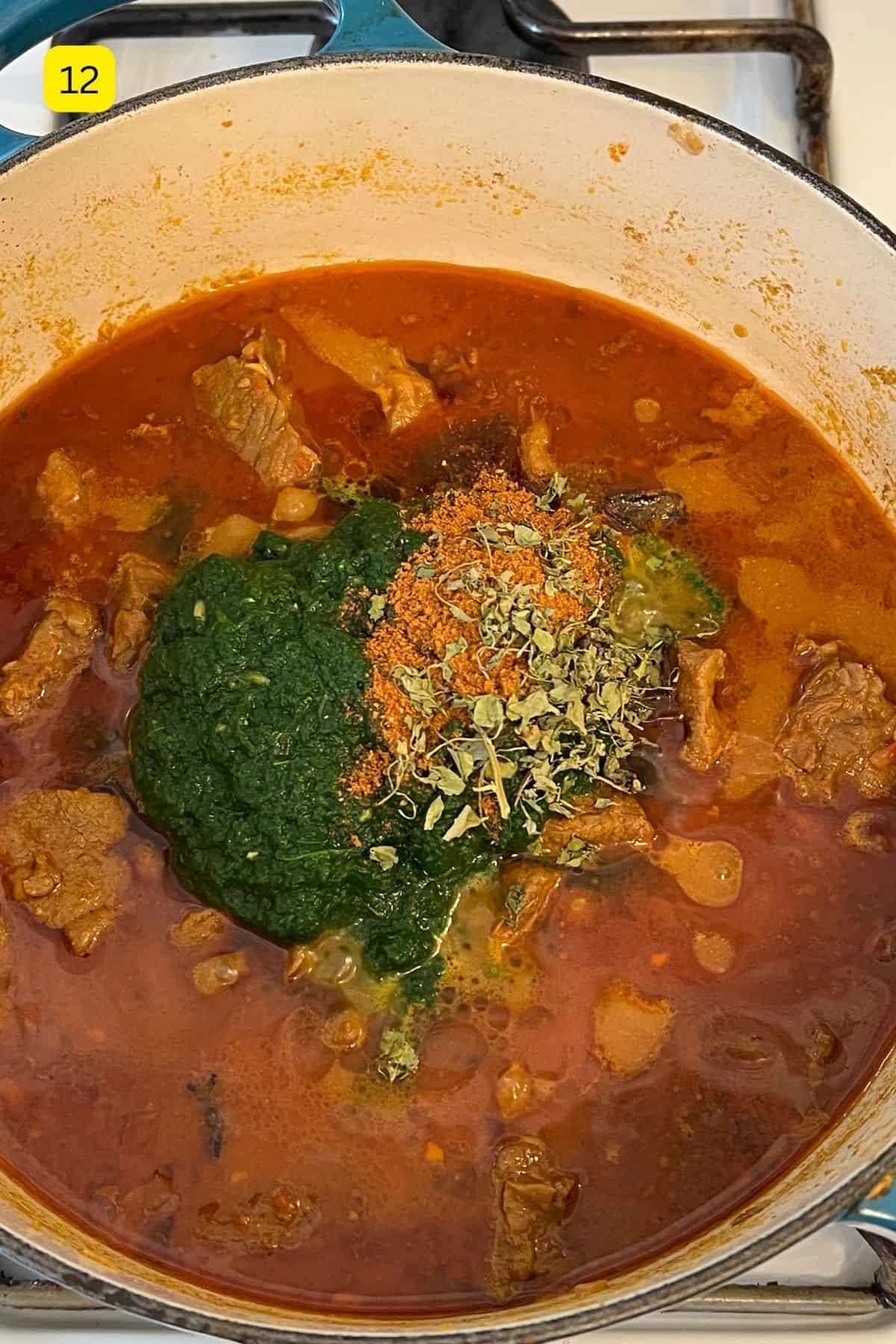 Adding spinach puree and finsishing spices to lamb palak.