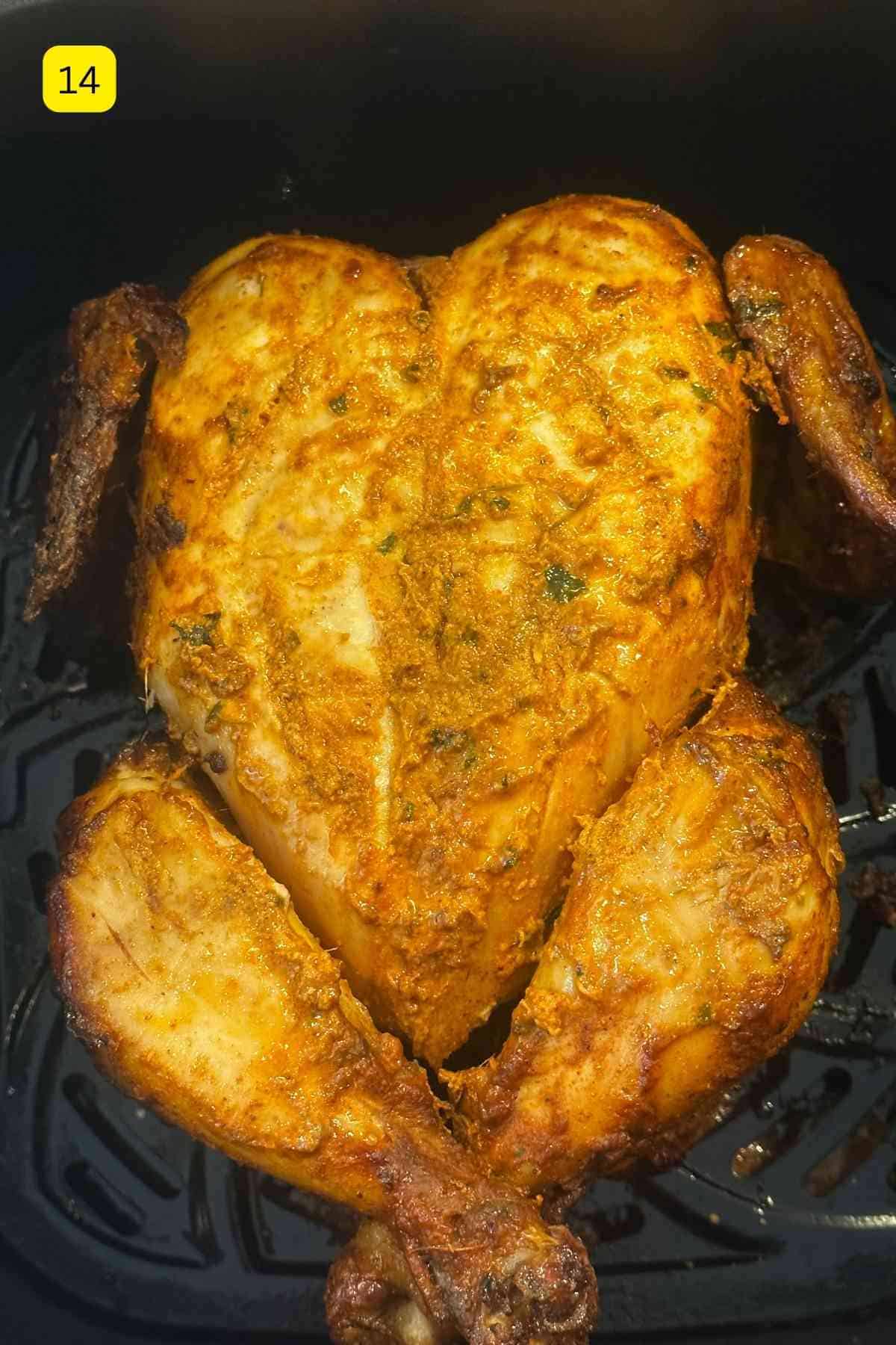 Whole tandoori chicken flipped with chicken breast facing up.