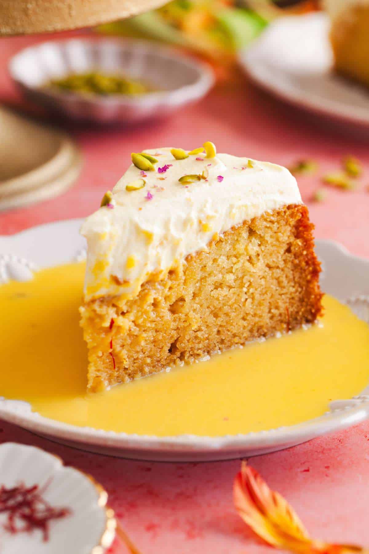 Slice of cake served with mango flavored milk.