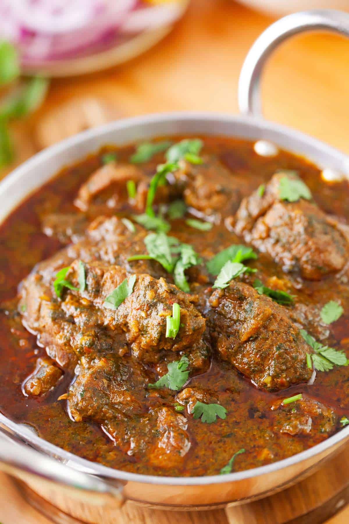 Lamb palak garnished with fresh chopped cilantro.