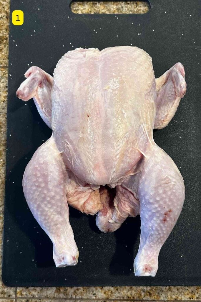 Whole Chicken With Skin placed on a plastic cutting board.