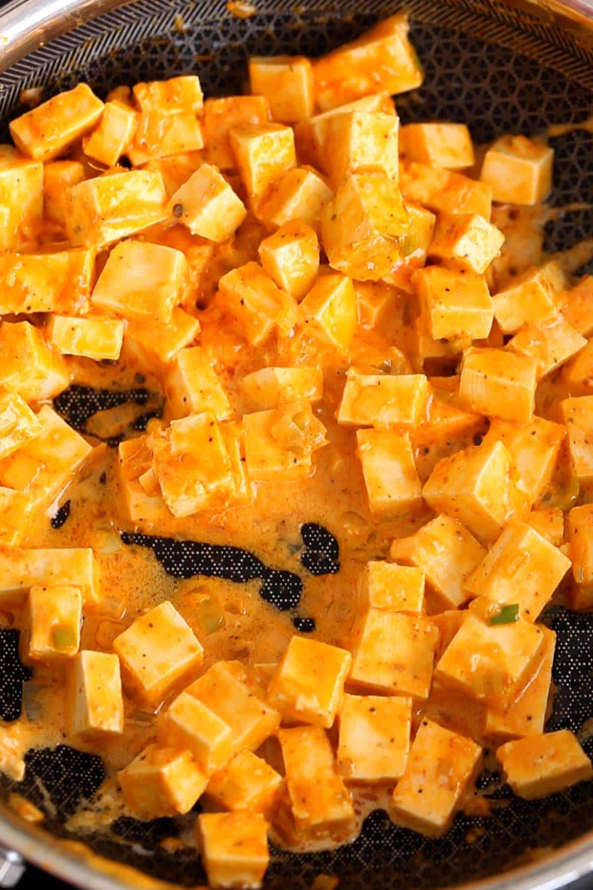 Peri peri paneer topping on a non stick pan.