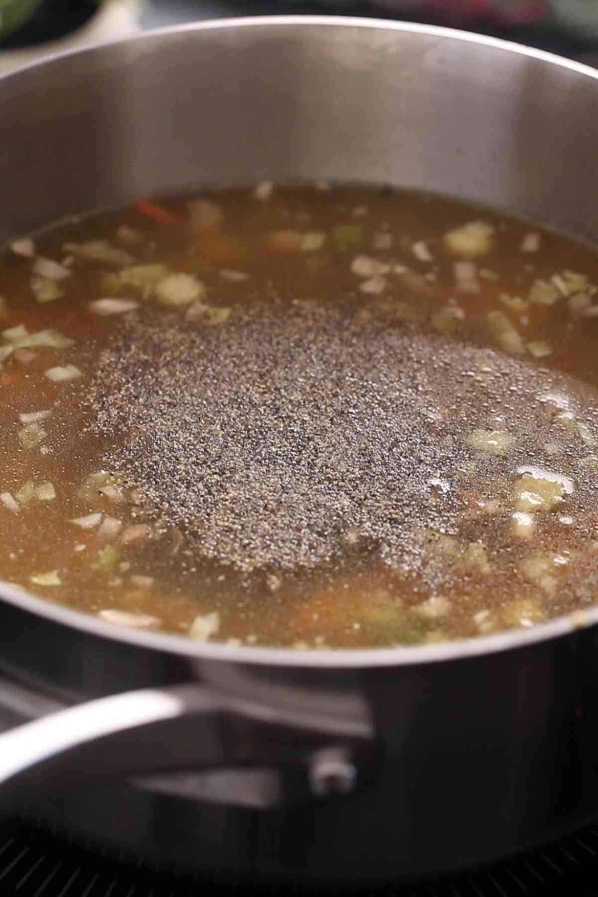 Adding spices and chinese sauces to the manchow soup.
