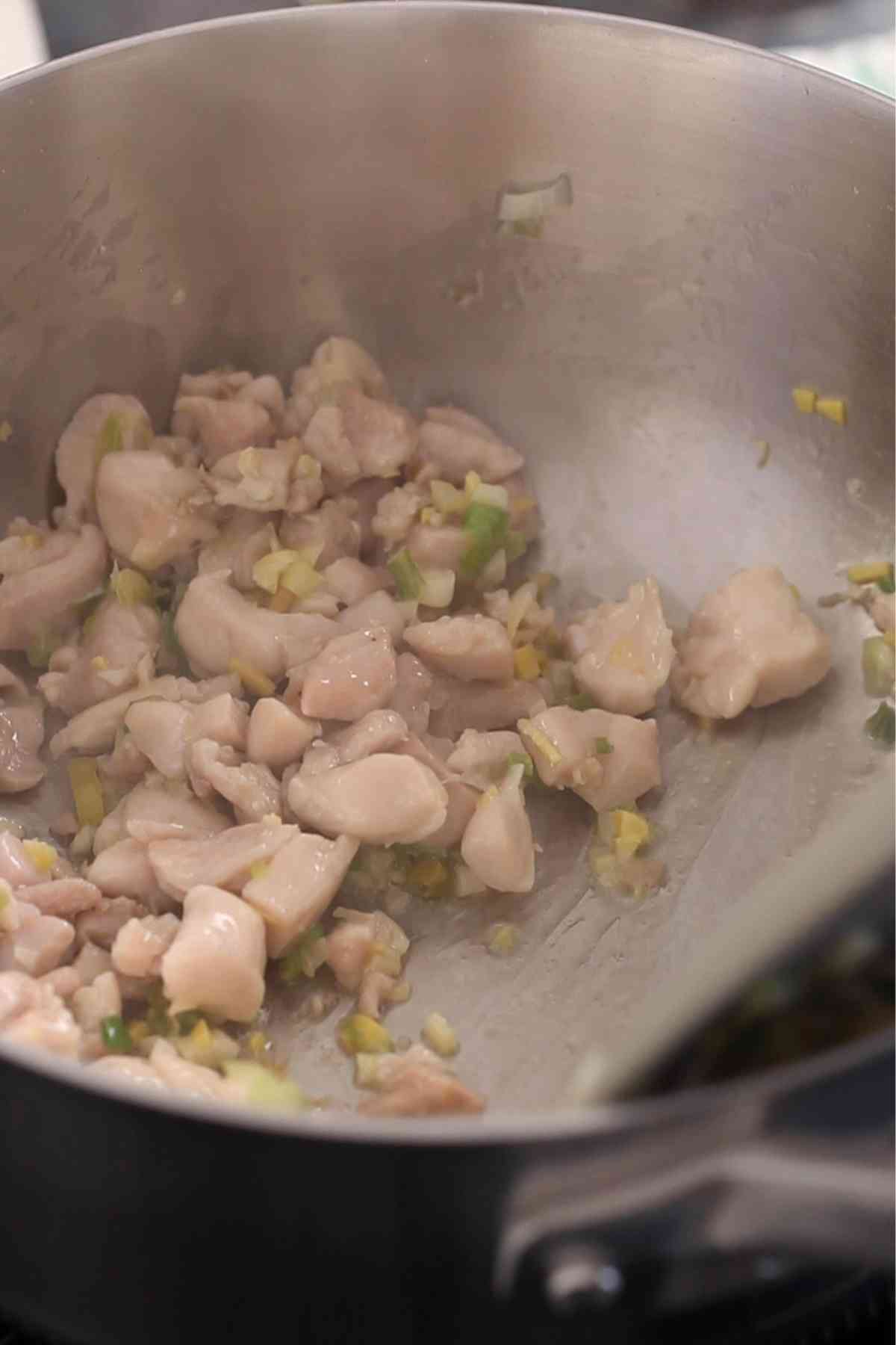 Chicken is stir fried until its cooked.
