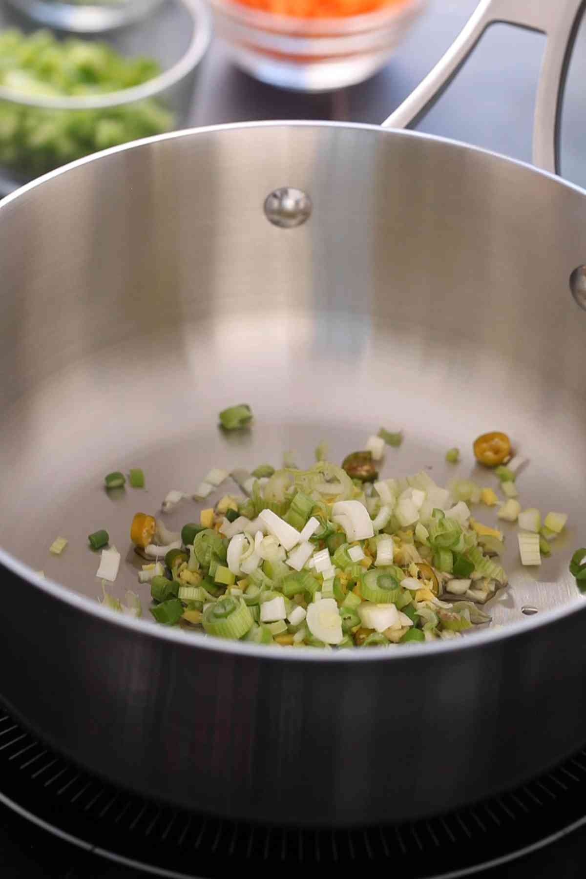 Ginger garlic and onion frying in oil in a pot.