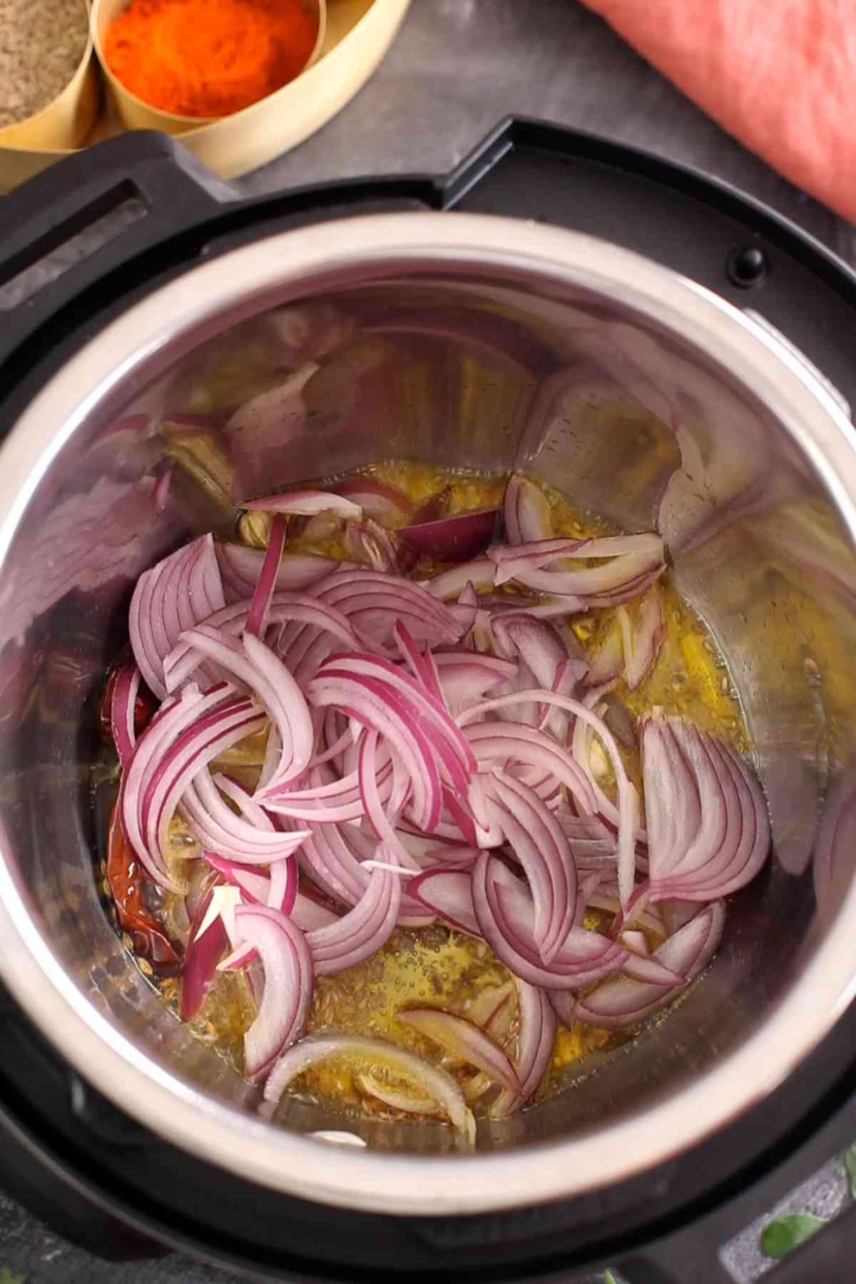 Sliced onions added to mustrad oil.