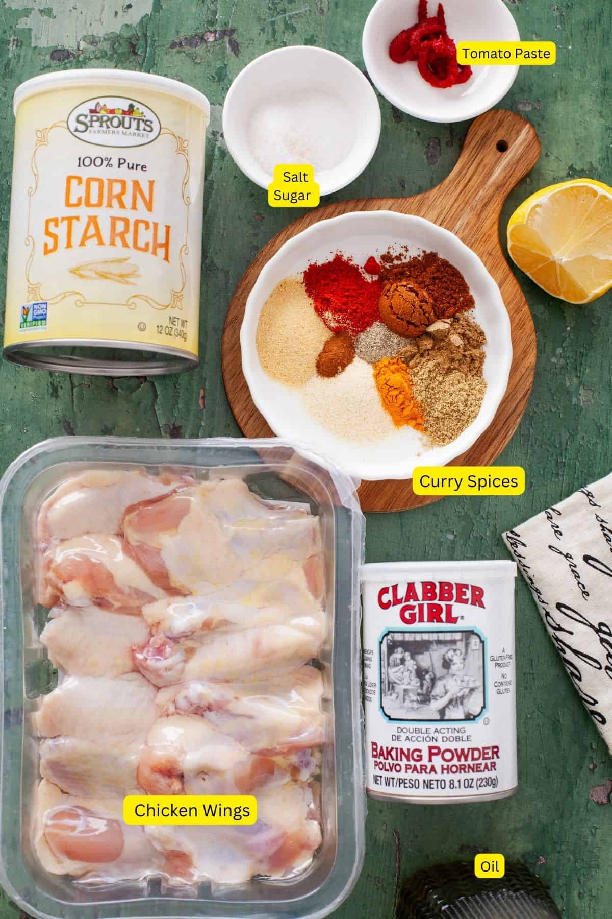 Ingredients for curry chicken wings place on a green background.