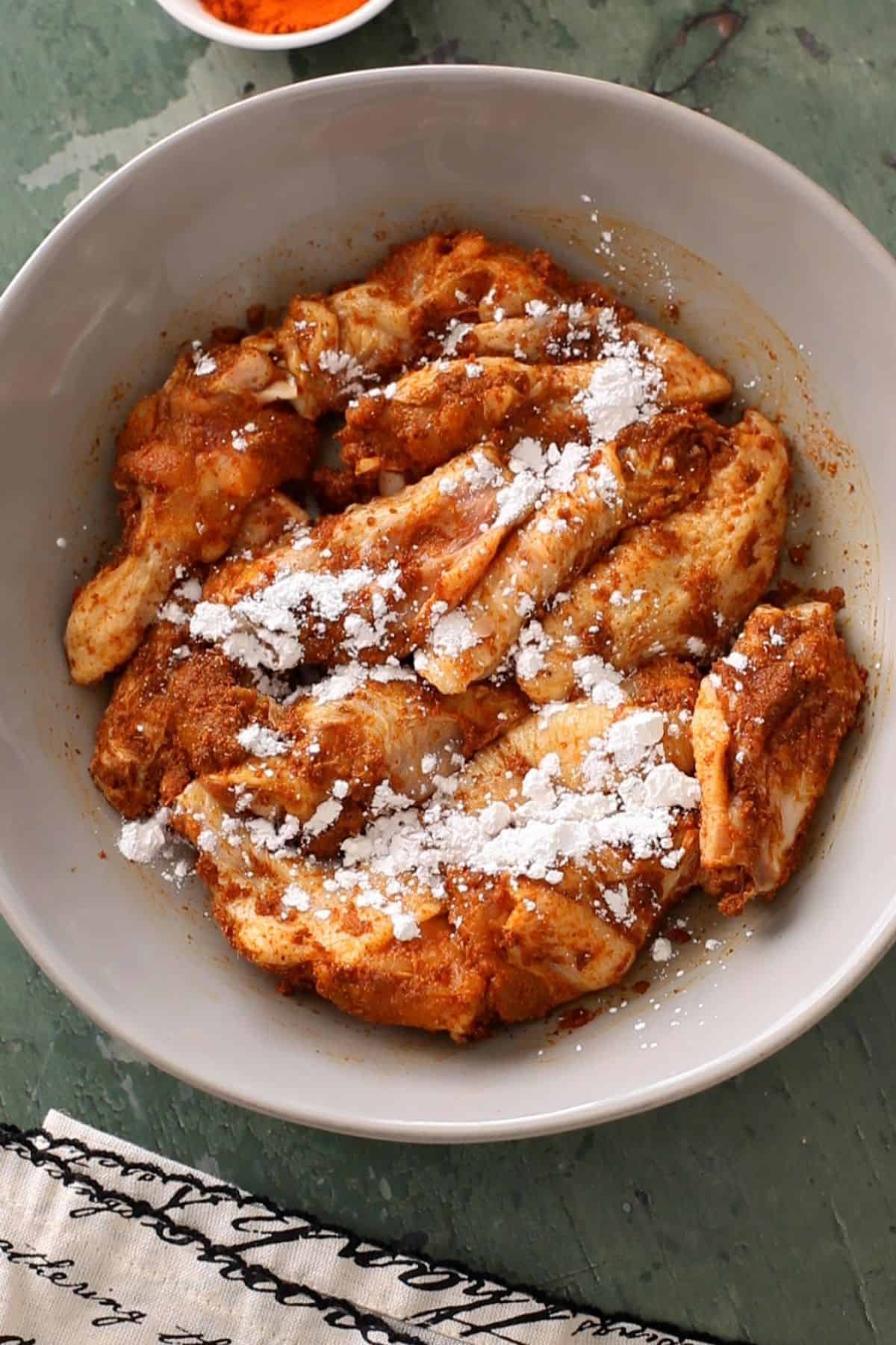 Marinated chicken wings sprinkled with cornstarch and baking powder.