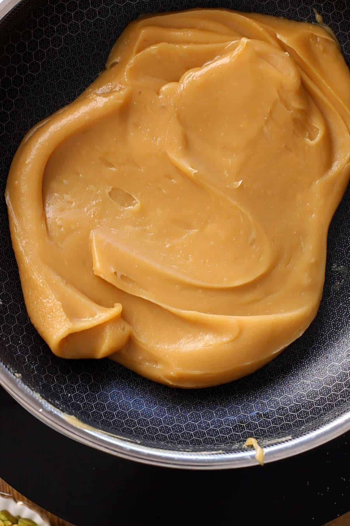 Cook the besan halwa on low heat until it leaves the sides of pan and becomes smooth.