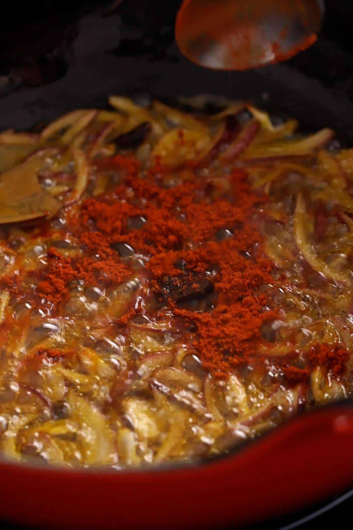 Adding kashmiri chili powder to browned onion.