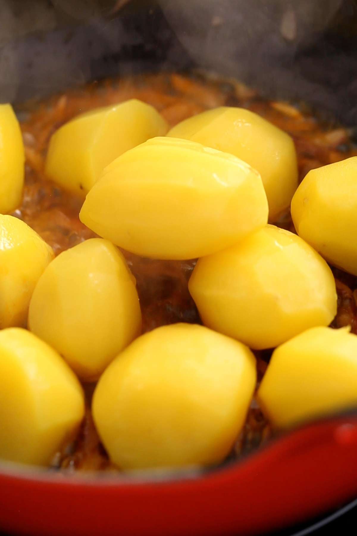 Adding potatoes to the cooking pot.