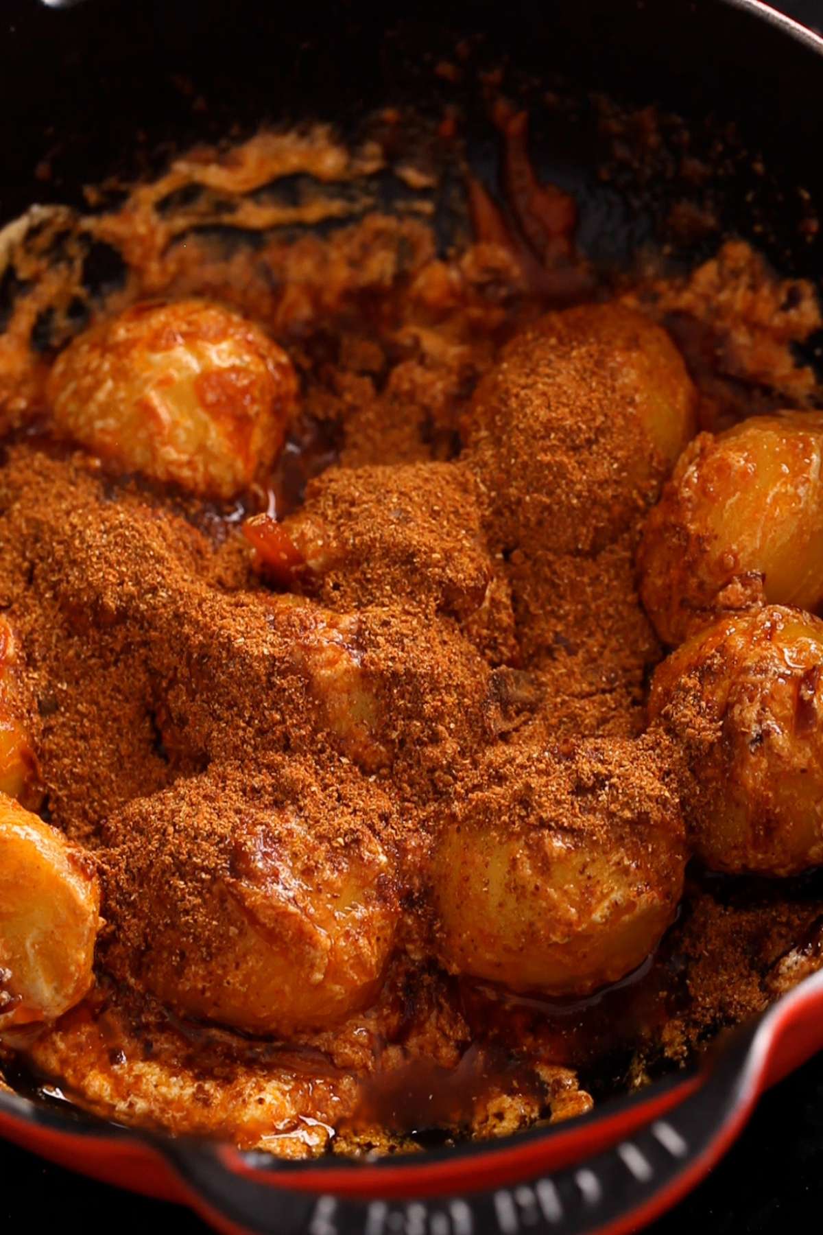 Adding the spice powder to the potatoes.