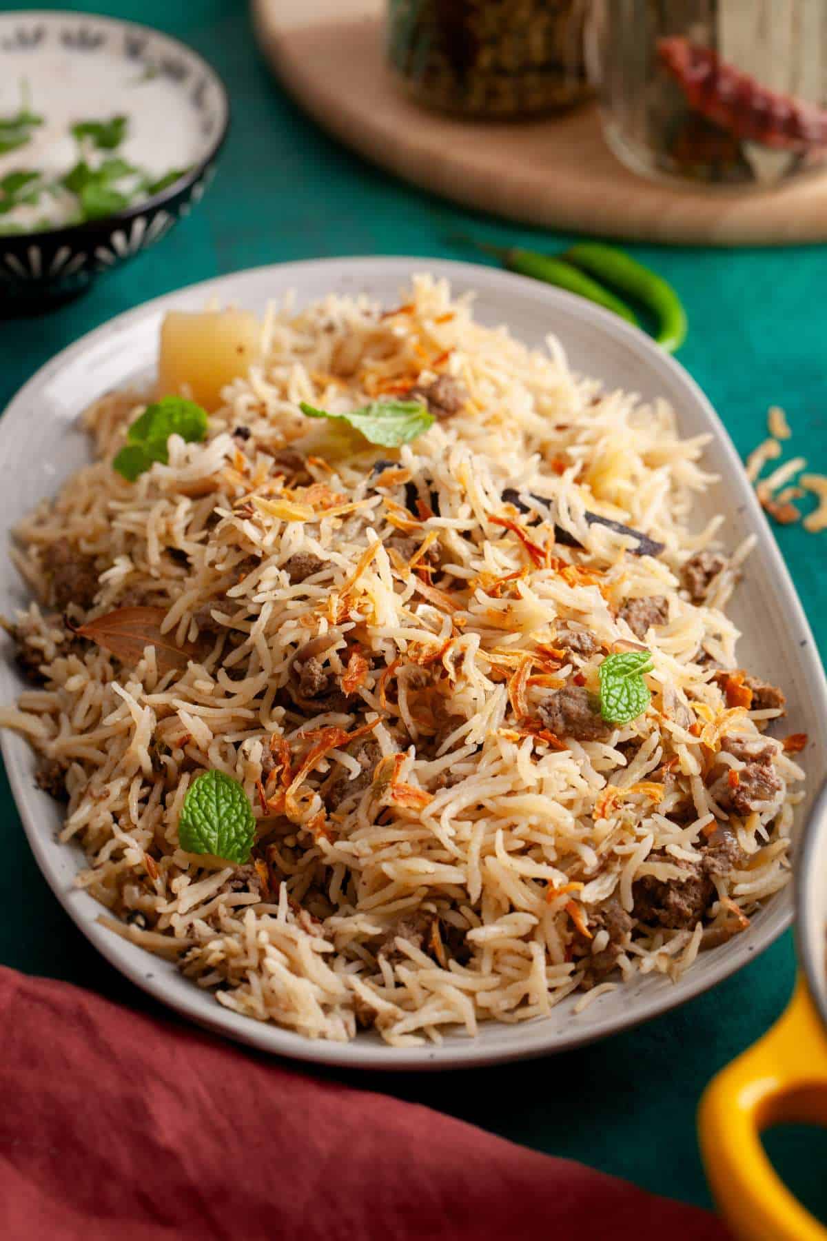 Angle view of kheema pulao in a grey platter.
